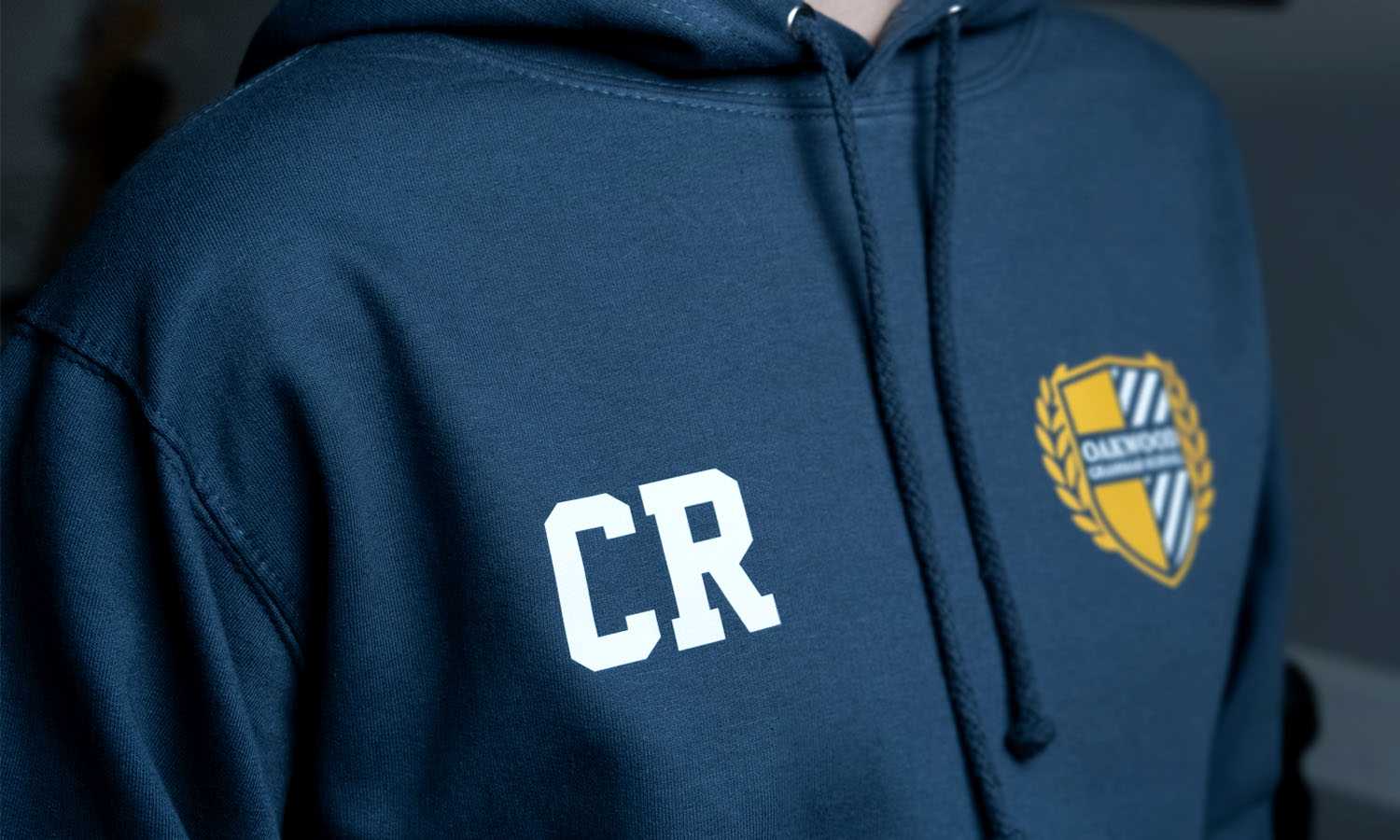 Photograph of the front of a leavers hoodie with the student's individual initials printed on the chest area and the school badge included on the opposite side.
