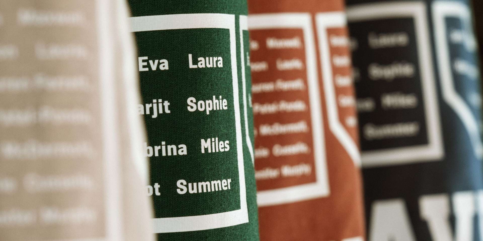 close up of four leavers hoodies hung up and zoomed in on the names within the number design on the back of the hoodie